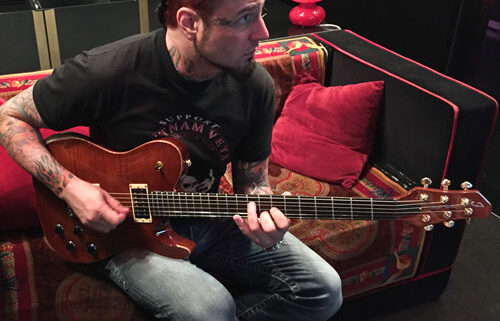 Man playing guitar on a couch.