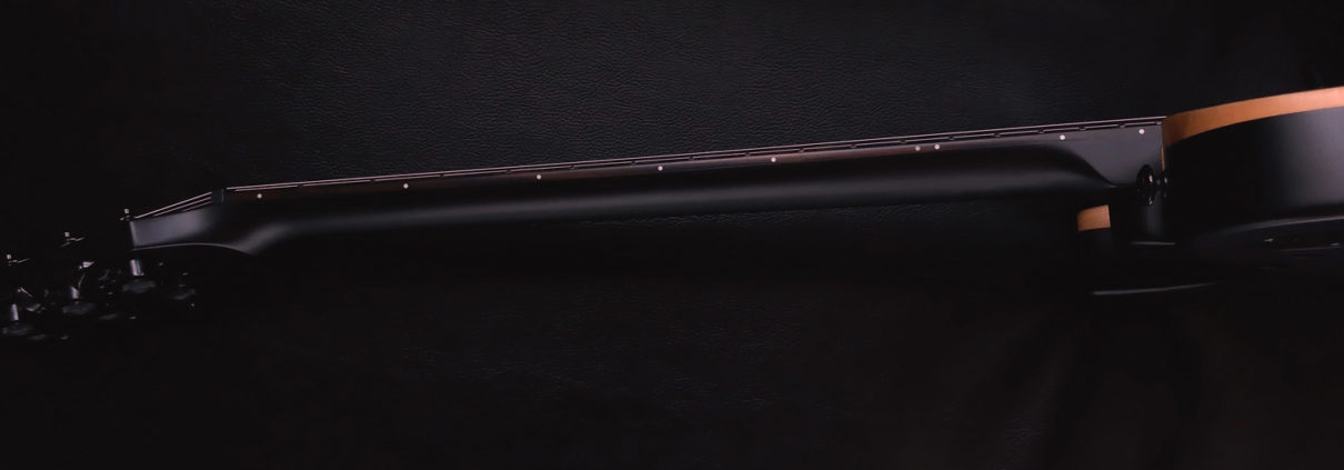 Close-up of a coiled black cable on a dark surface.